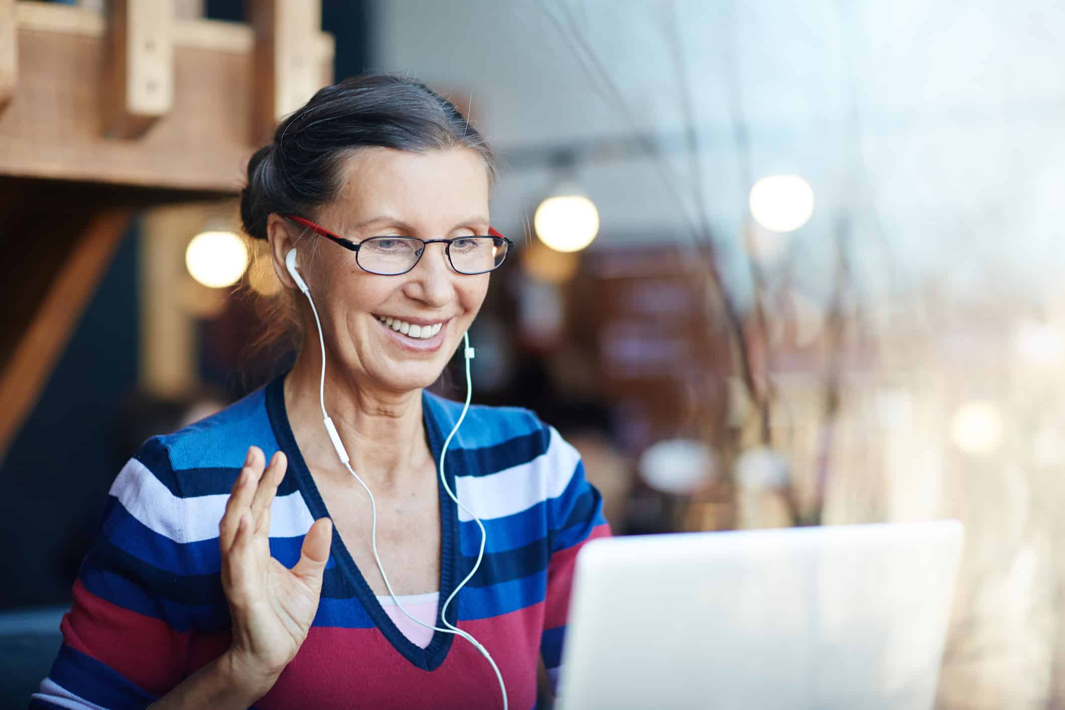 Happy blogger with earphones sitting in front of laptop
